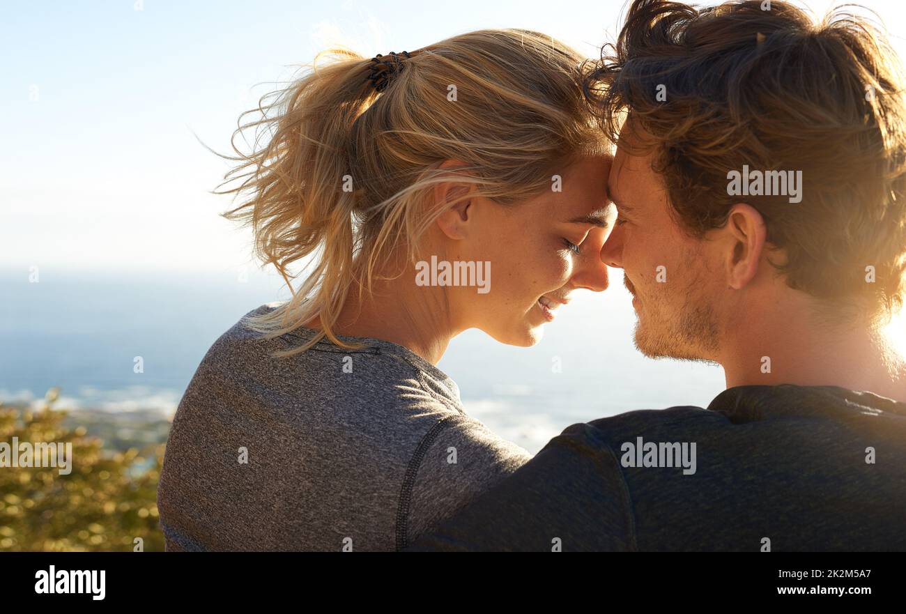 Le silence parle mille mots. Photo d'un couple aimant assis sur un banc surplombant l'océan. Banque D'Images