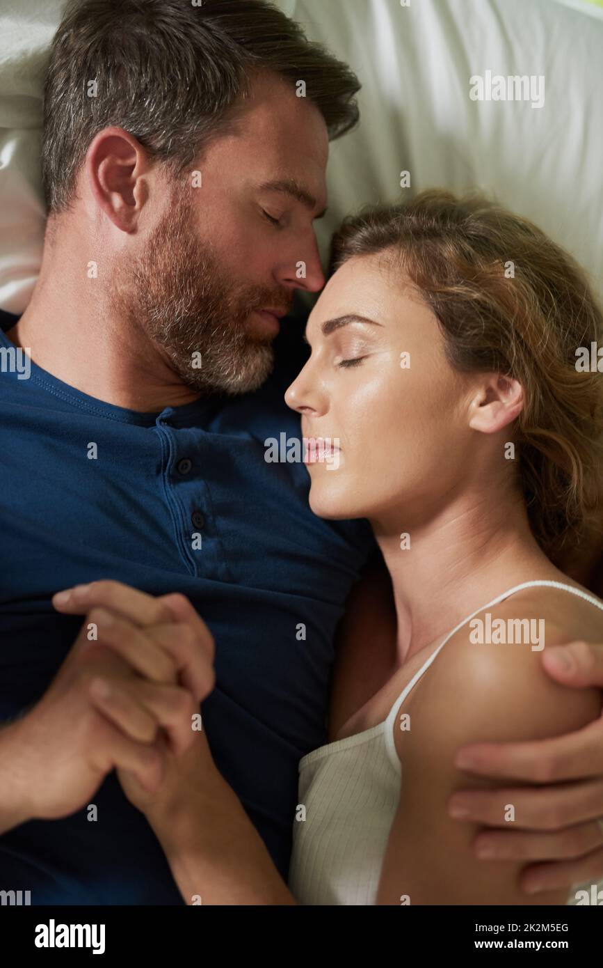 Les moments qui rendent la vie parfaite. Photo d'un heureux couple d'âge moyen se relaxant au lit ensemble. Banque D'Images