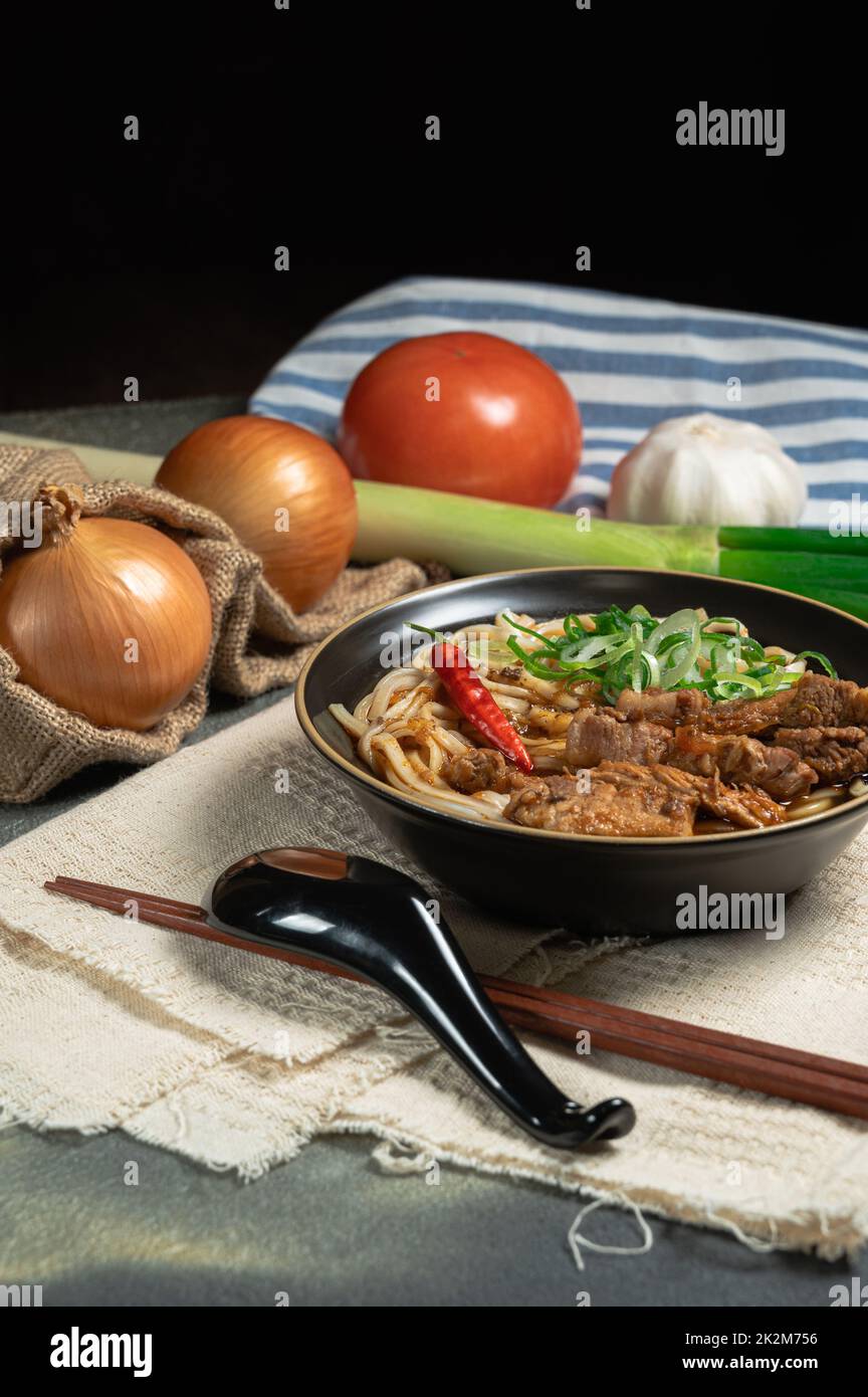 nouilles de porc taïwanaises traditionnelles faites maison avec bouillon de porc et assaisonnement épicé, tomate, oignon, poireau, ail et gingembre. Banque D'Images