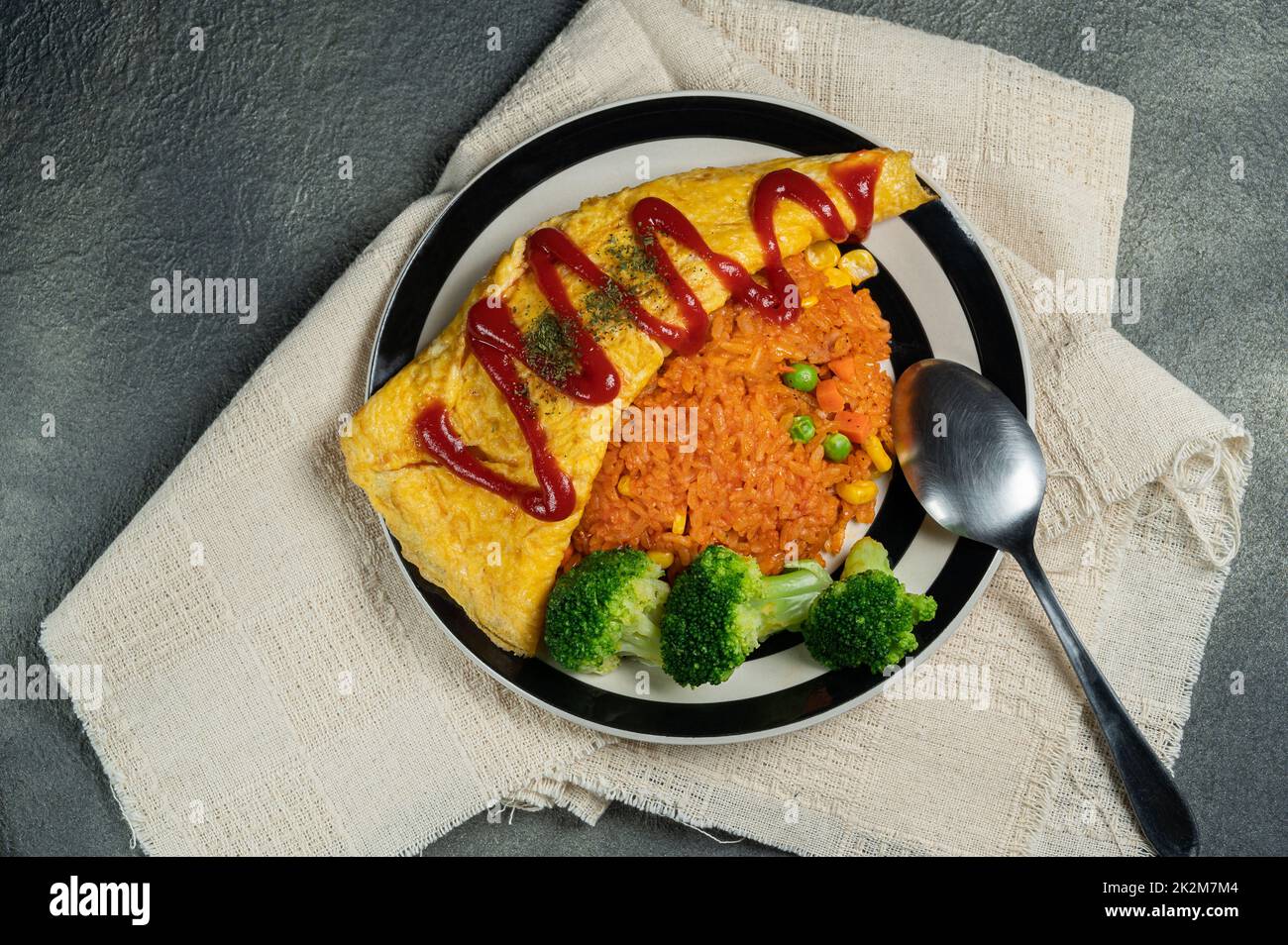 omelette japonaise maison (omelette) avec riz au poulet japonais, broccolit et fond sombre. Banque D'Images