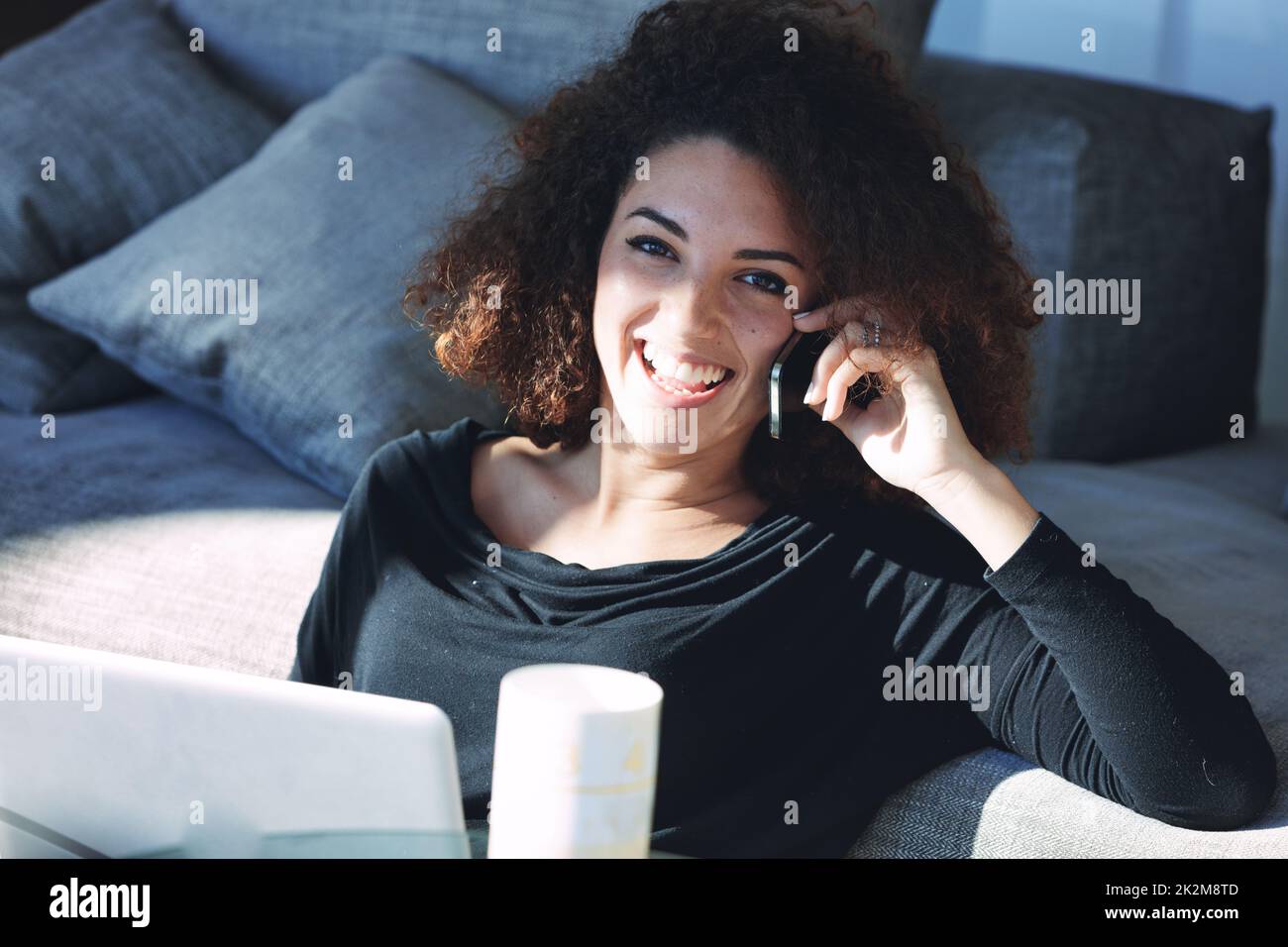 Une jeune femme heureuse bavarde sur son smartphone Banque D'Images