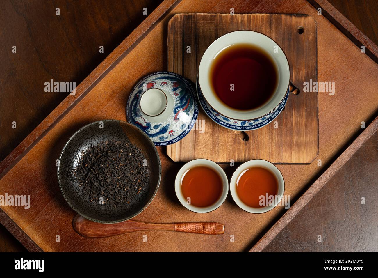 tasse de thé traditionnelle chinoise en porcelaine et feuille de thé sur un panneau ancien en bois Banque D'Images