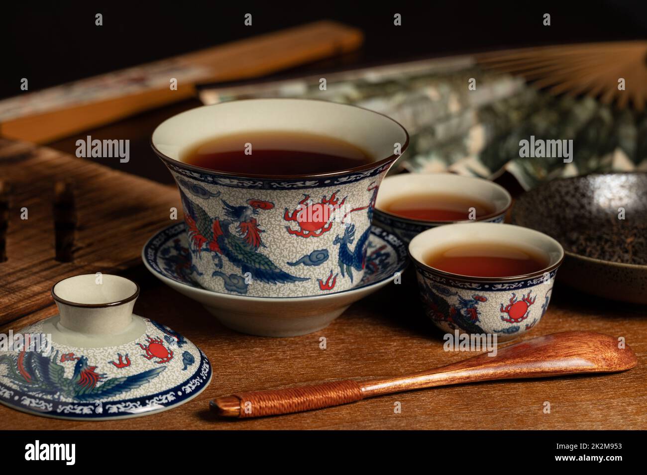 tasse de thé traditionnelle chinoise en porcelaine et feuille de thé sur un panneau ancien en bois Banque D'Images