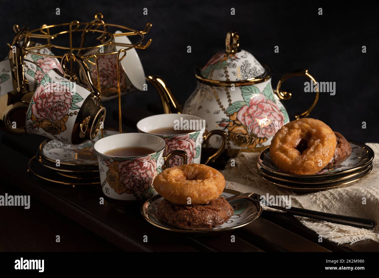 image du thé de l'après-midi avec thé noir, beignets et belle théière et tasse à bord Banque D'Images