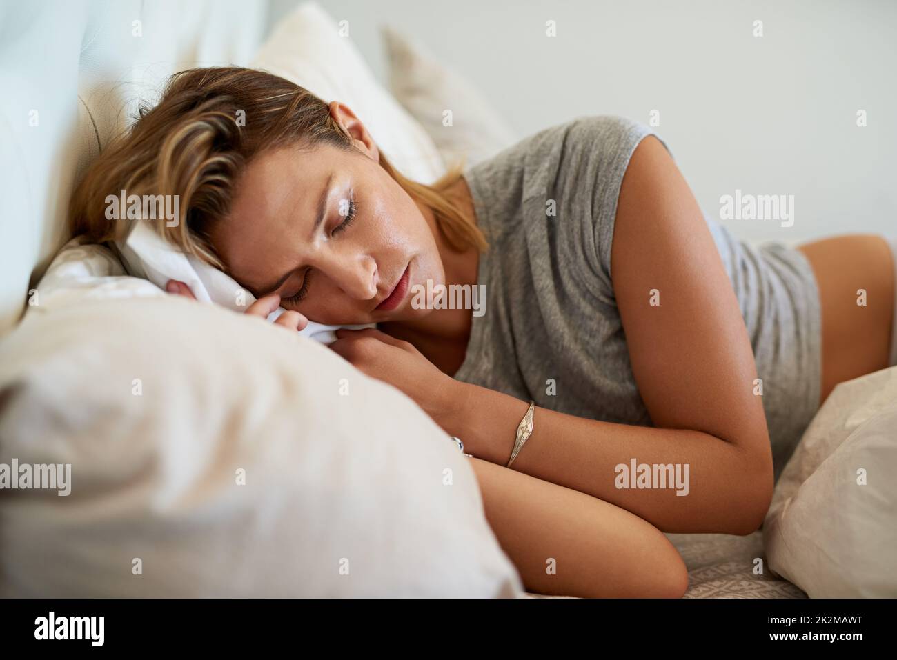 Nous avons tous besoin de notre sommeil de beauté. Photo courte d'une femme attrayante dormant sur le côté dans le lit à la maison. Banque D'Images