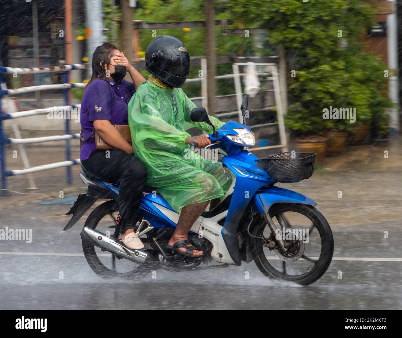 SAMUT PRAKAN, THAÏLANDE, SEP 21 2022, promenade en couple sur une moto sous de fortes pluies Banque D'Images