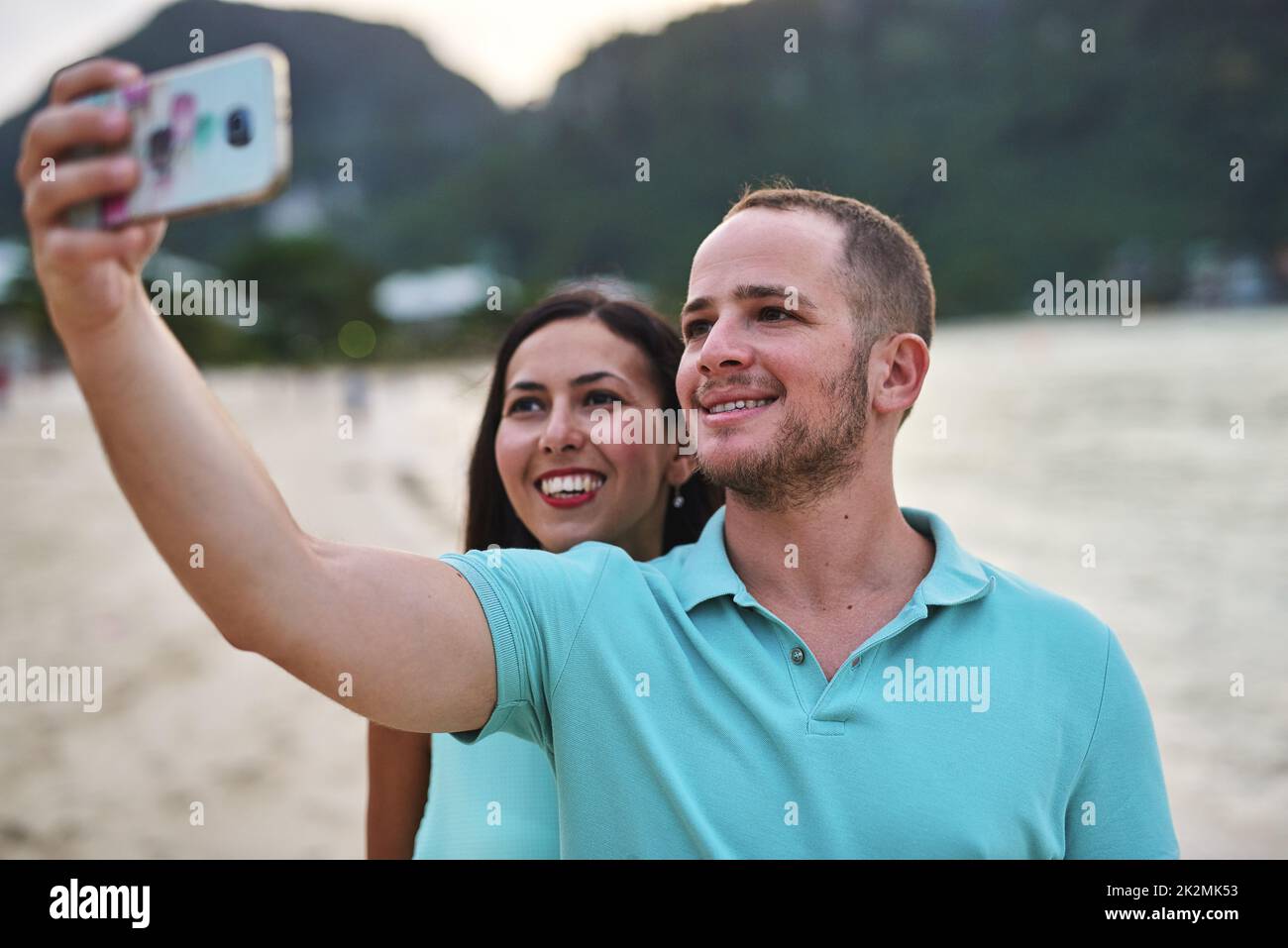 Partageons tout avec la famille à la maison. Photo d'un couple prenant un selfie sur la plage. Banque D'Images