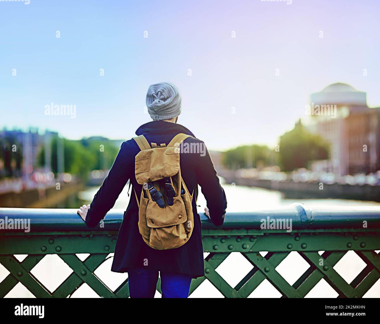 La ville met tout en perspective. Vue arrière d'un jeune homme regardant la vue sur la ville depuis un pont. Banque D'Images