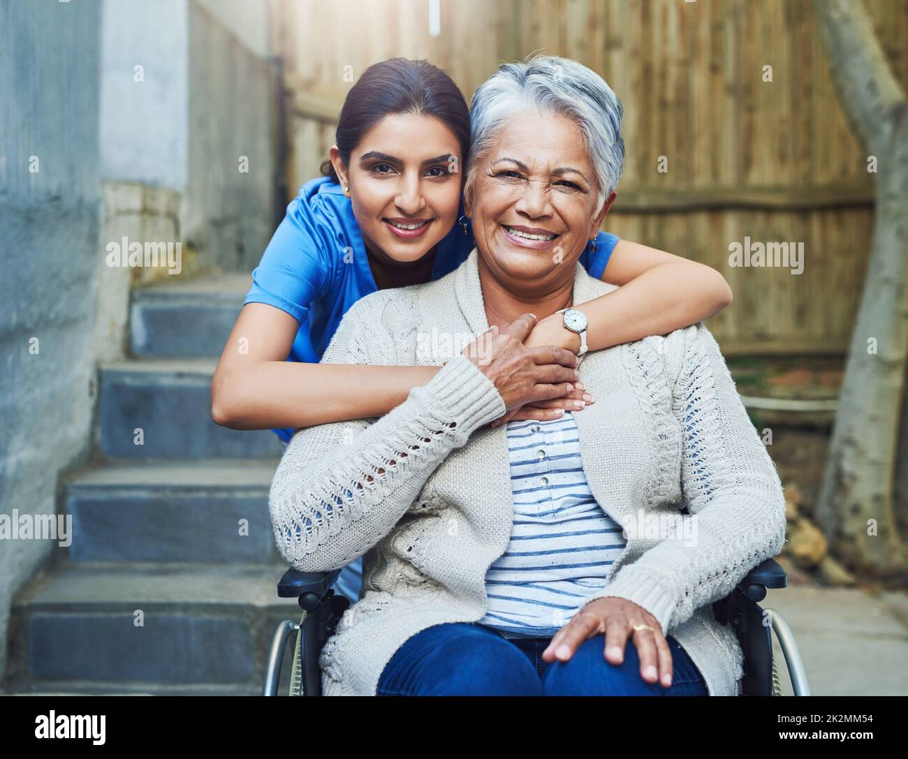 Vous n'avez pas à chercher loin pour trouver un peu d'aide. Portrait d'une jeune infirmière gaie tenant un patient âgé en fauteuil roulant comme support à l'extérieur pendant la journée. Banque D'Images