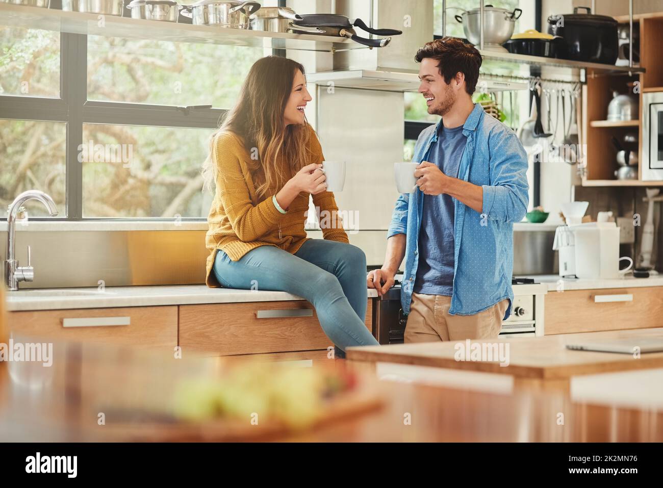 Se rattraper dans la cuisine. Photo d'un jeune couple affectueux conversant dans sa cuisine. Banque D'Images