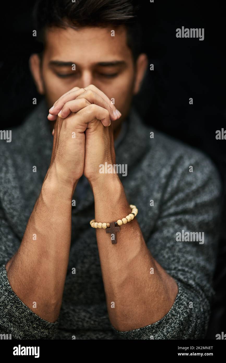 Sa foi est forte. Gros plan d'un jeune homme priant avec ses yeux fermés. Banque D'Images