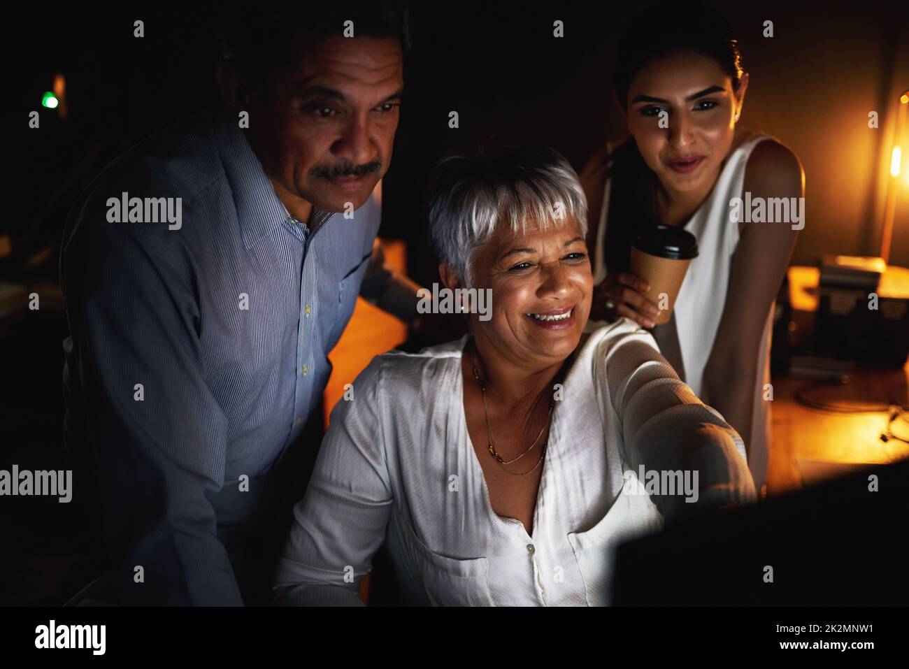 Leurs projets n'ont besoin que de quelques petites touches supplémentaires. Photo d'un groupe d'hommes d'affaires travaillant tard sur un ordinateur dans un bureau. Banque D'Images