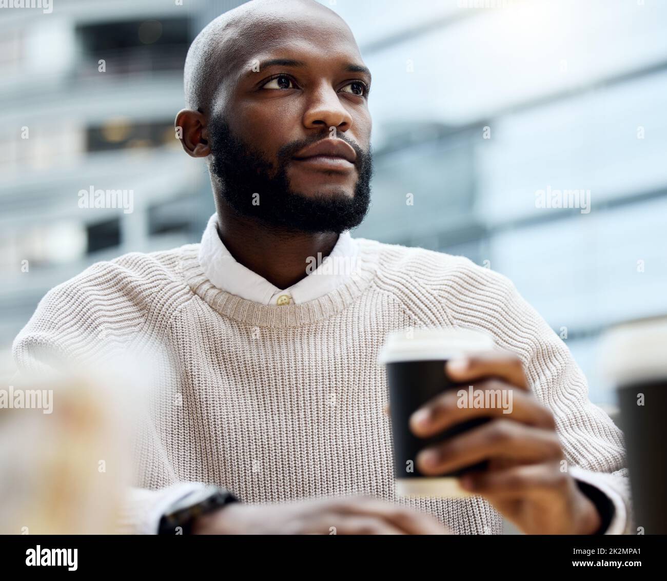 Le café suscite toutes les pensées ambitieuses. Photo d'un jeune homme d'affaires qui a l'air attentionné tout en buvant un café à l'extérieur d'un bureau. Banque D'Images