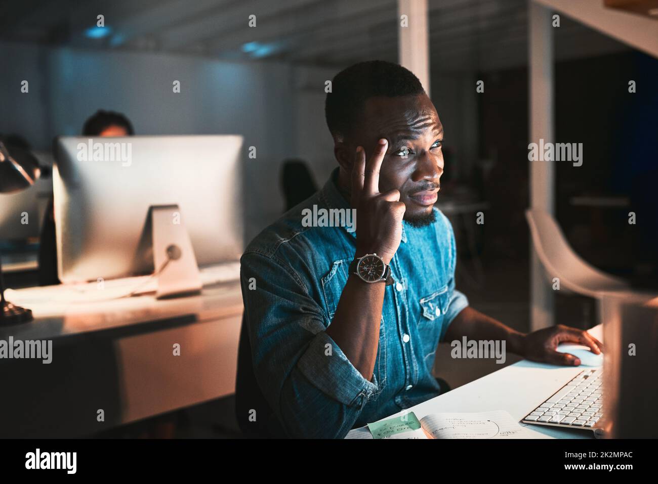 HES a frappé un mur. Prise de vue en grand angle d'un jeune homme concepteur qui a l'air stressé en travaillant sur son ordinateur au bureau. Banque D'Images