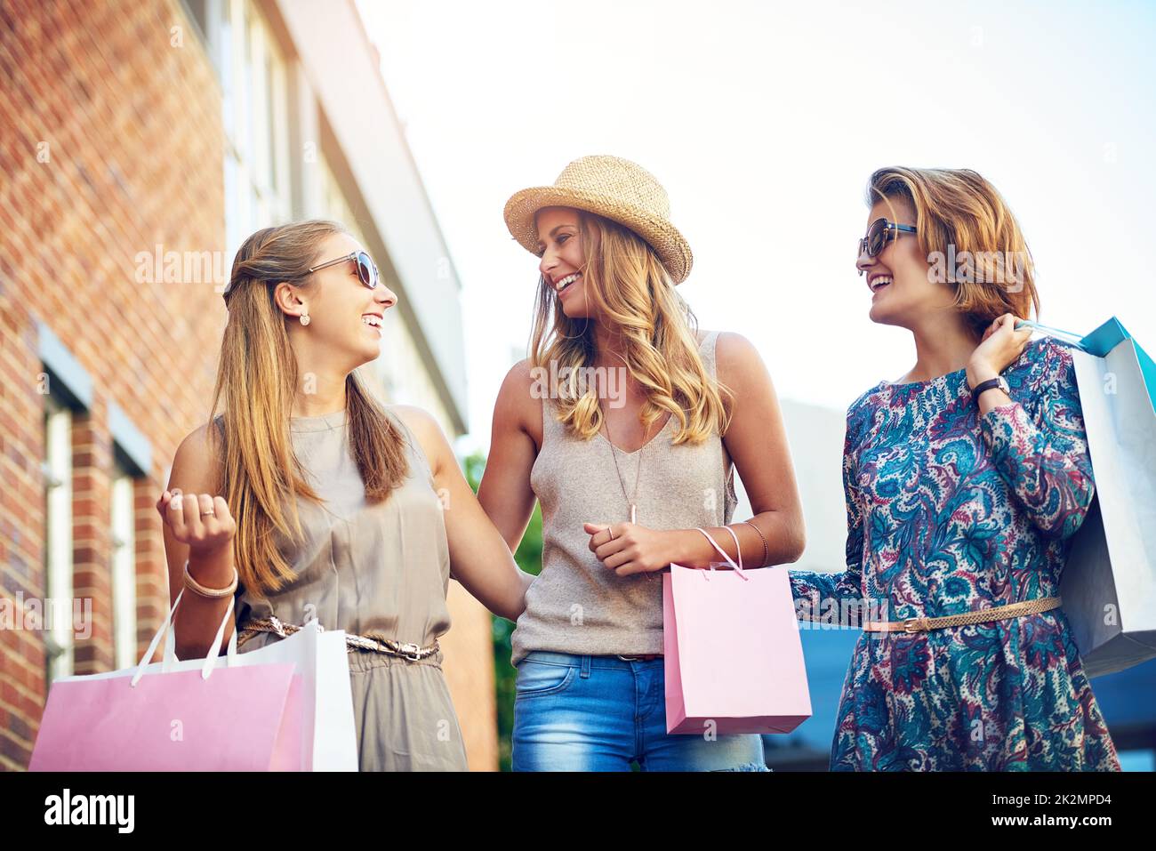 Voyons qui peut trouver la meilleure offre. Photo courte de trois jeunes amies qui magasinent dans le centre-ville. Banque D'Images