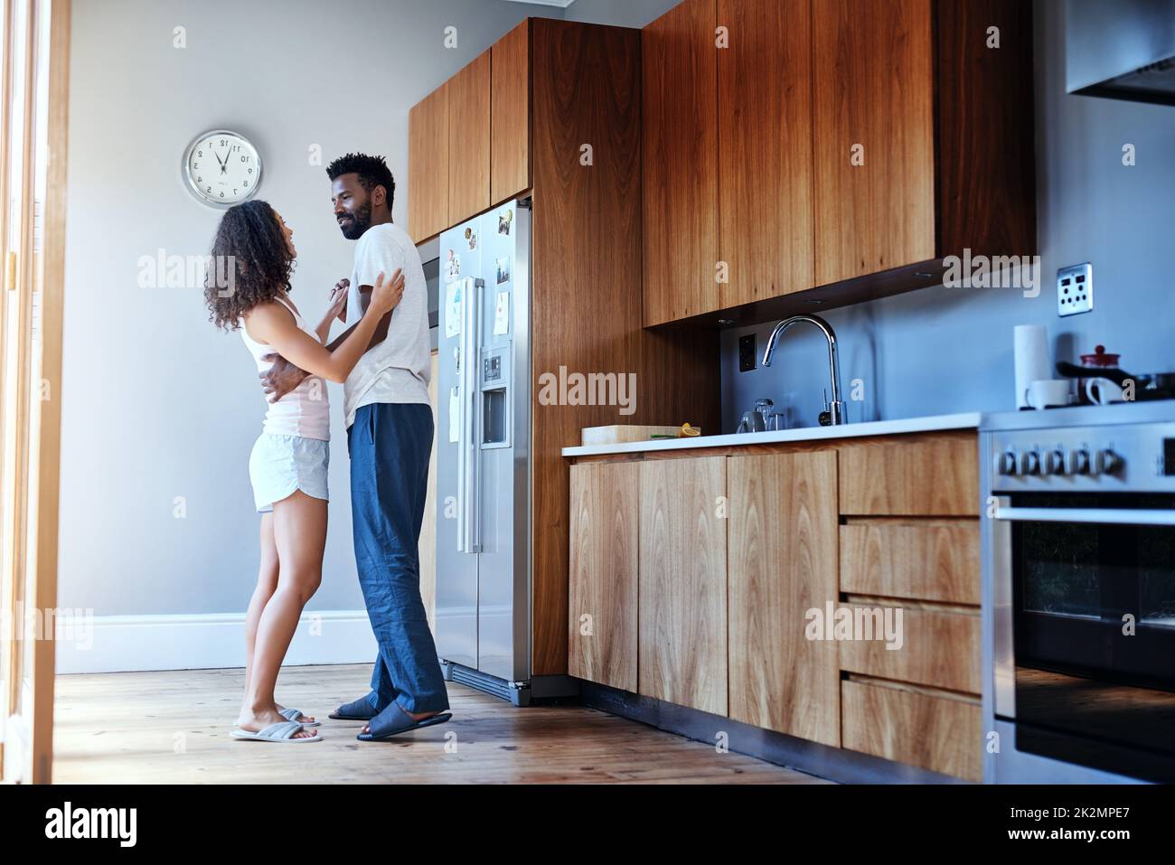 Danse avec moi. Prise de vue en longueur d'un jeune couple affectueux dansant dans sa cuisine à la maison. Banque D'Images