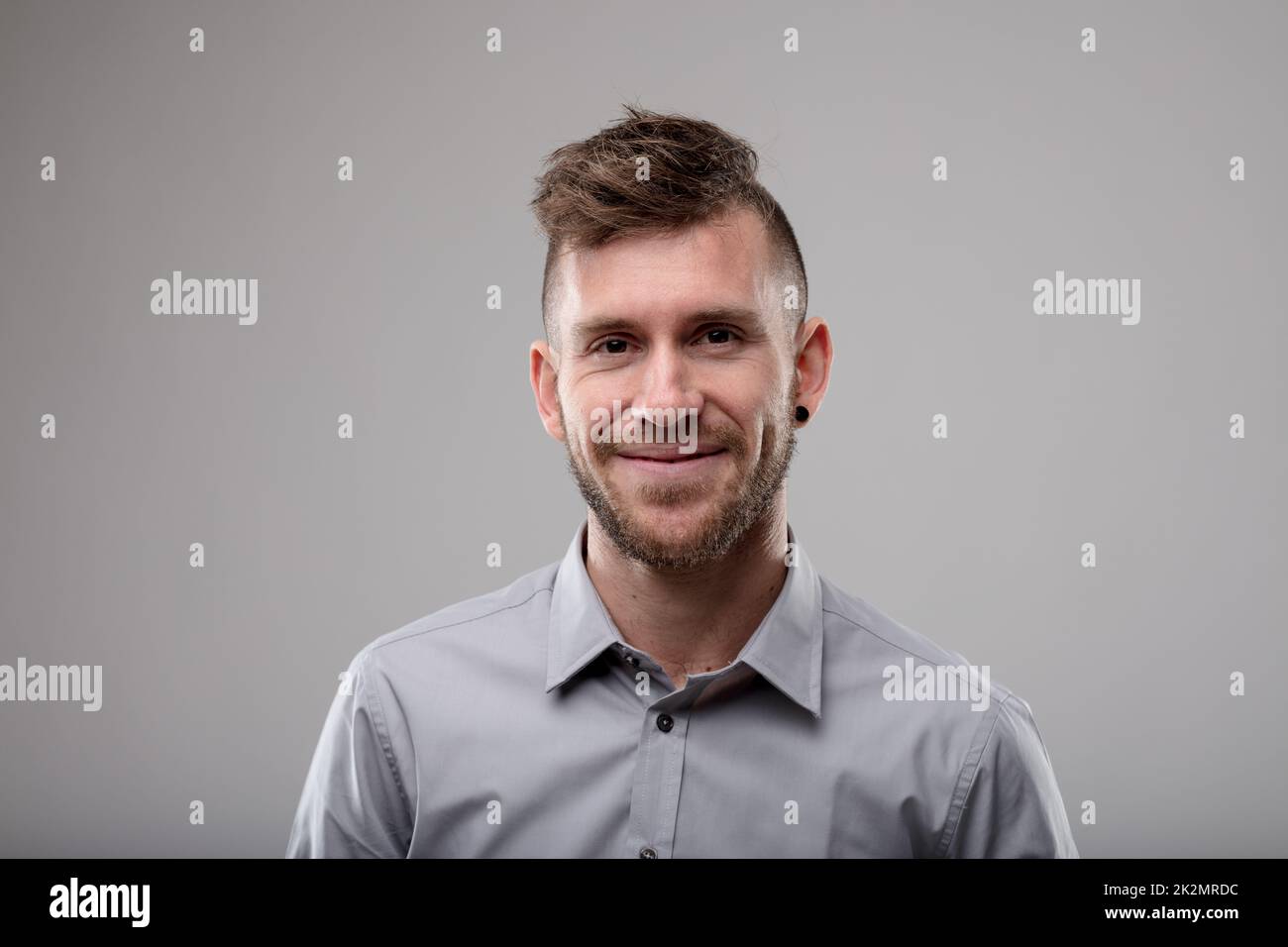 Souriant homme amical avec une coupe de cheveux moderne Banque D'Images