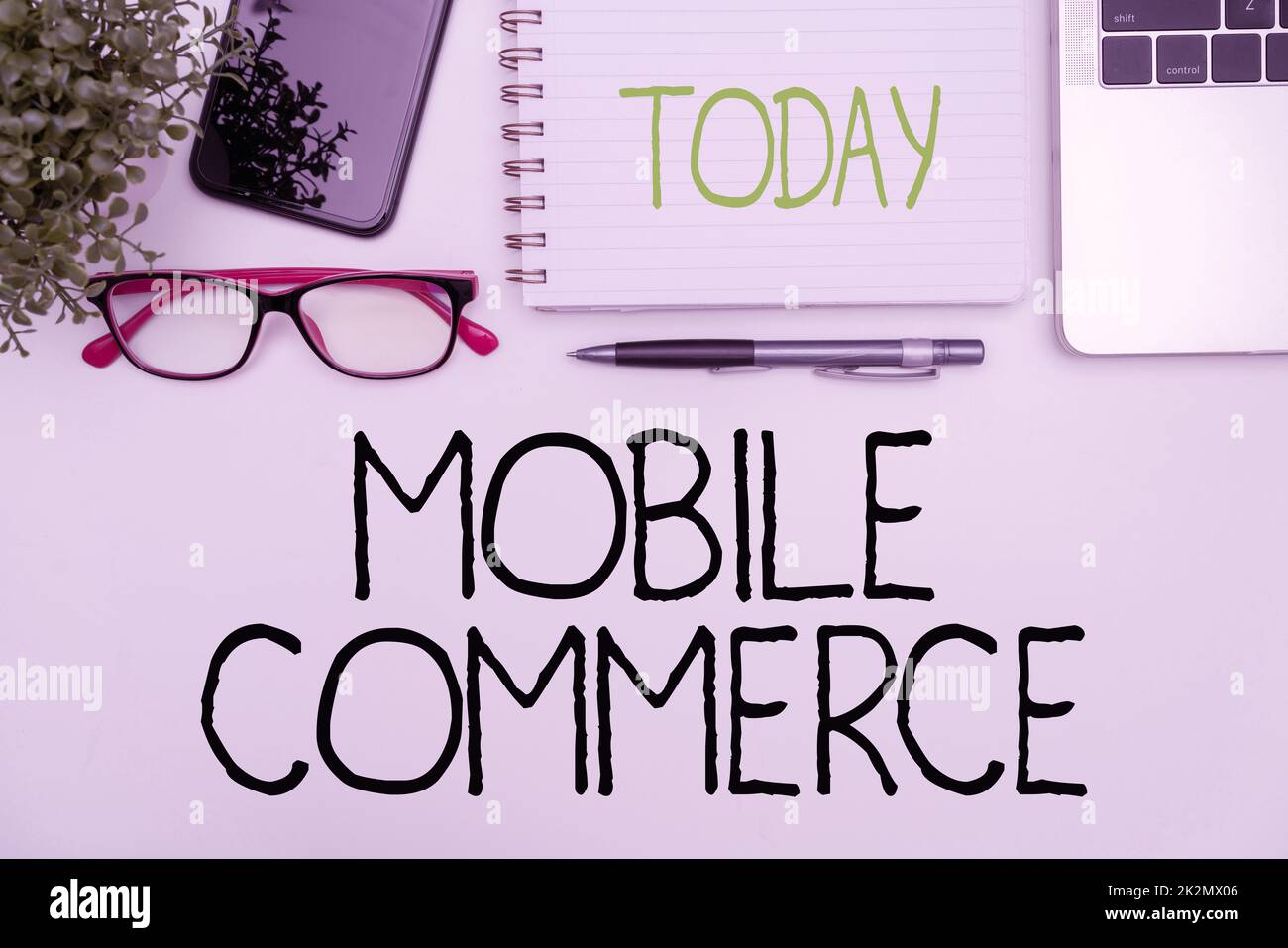 Affiche textuelle montrant Mobile Commerce. Approche commerciale utilisation du téléphone mobile pour effectuer des transactions commerciales en ligne fournitures de bureau sur le bureau avec clavier et lunettes et tasse à café pour le travail Banque D'Images