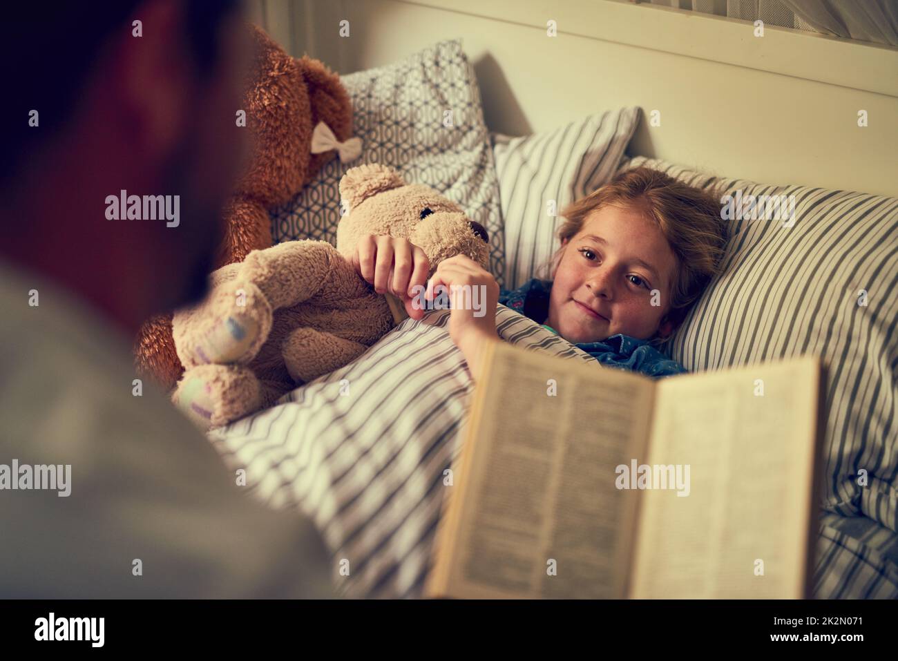 Des histoires magiques pour créer des rêves de sweetdreams. Photo rognée d'un père lisant une histoire de coucher à sa petite fille à la maison. Banque D'Images