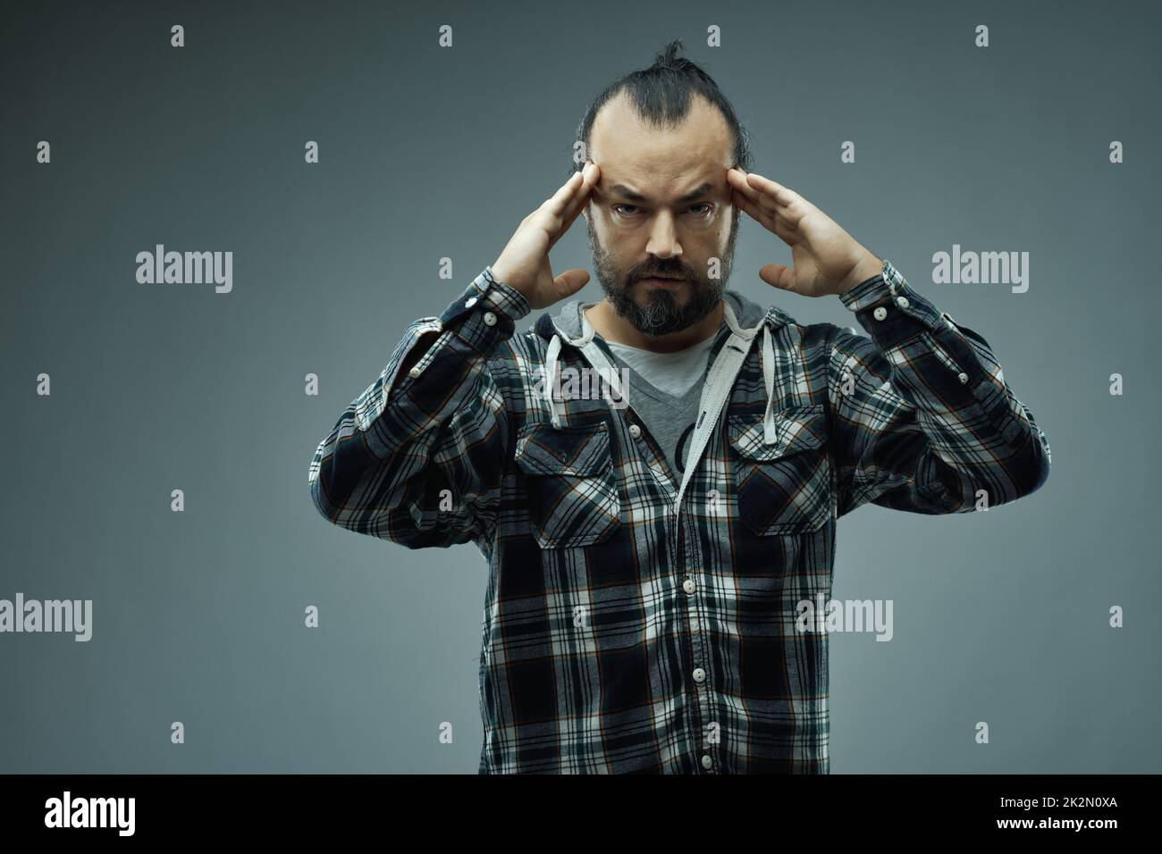 Homme regardant attentivement la caméra avec des frondes de concentration Banque D'Images