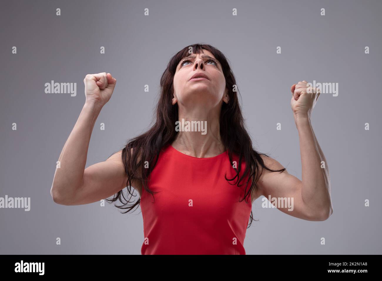 Une femme en colère s'accroche à ses poings dans la frustration Banque D'Images