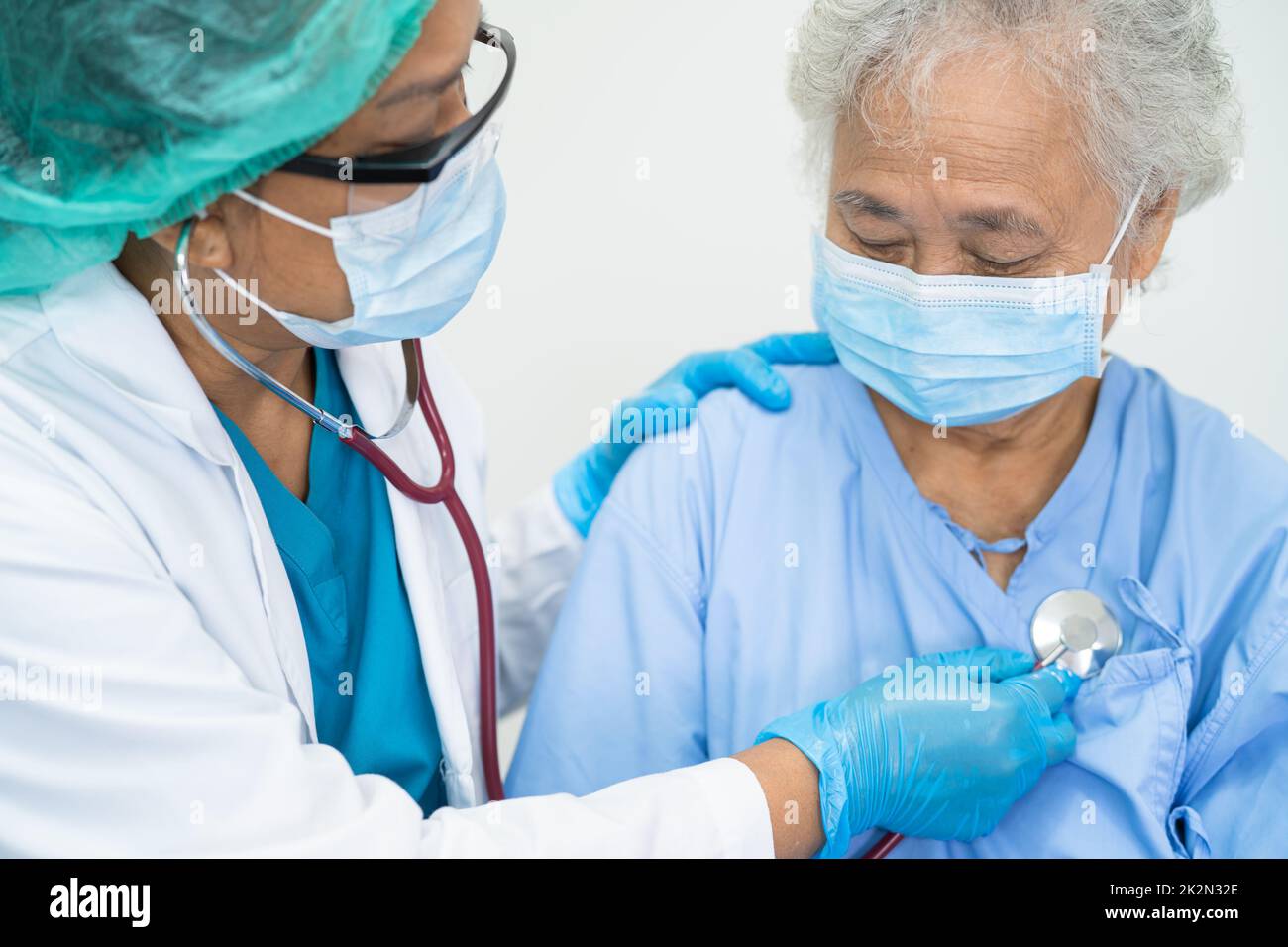 Aide médicale asiatique senior ou âgée femme âgée patient portant un masque facial à l'hôpital pour protéger l'infection de sécurité et tuer le coronavirus Covid-19. Banque D'Images