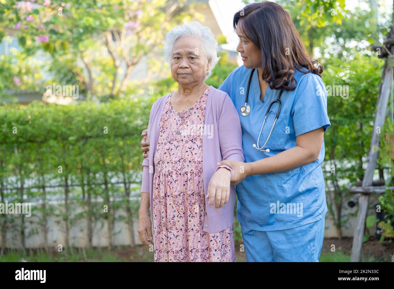 Médecin aide et soins Asian senior ou âgée femme utilisation de marcheur avec une bonne santé tout en marchant au parc dans de bonnes vacances fraîches. Banque D'Images