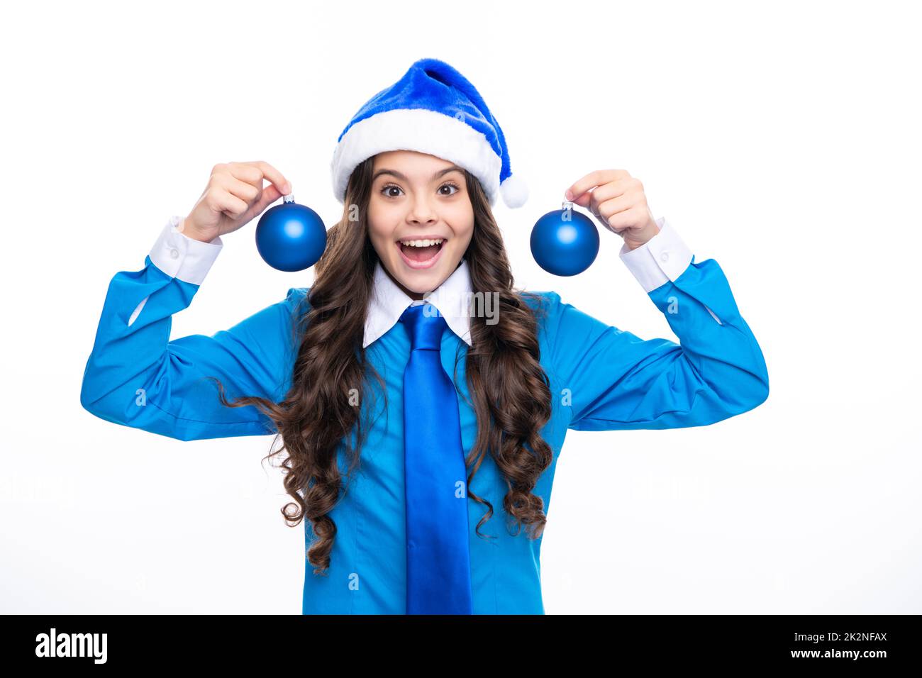 Portrait une jeune fille souriante avec chapeau de père noël bleu, chemise et cravate tenir boule de noël boule de boule isolée sur fond blanc. Soldes de Noël, Nouveau Banque D'Images