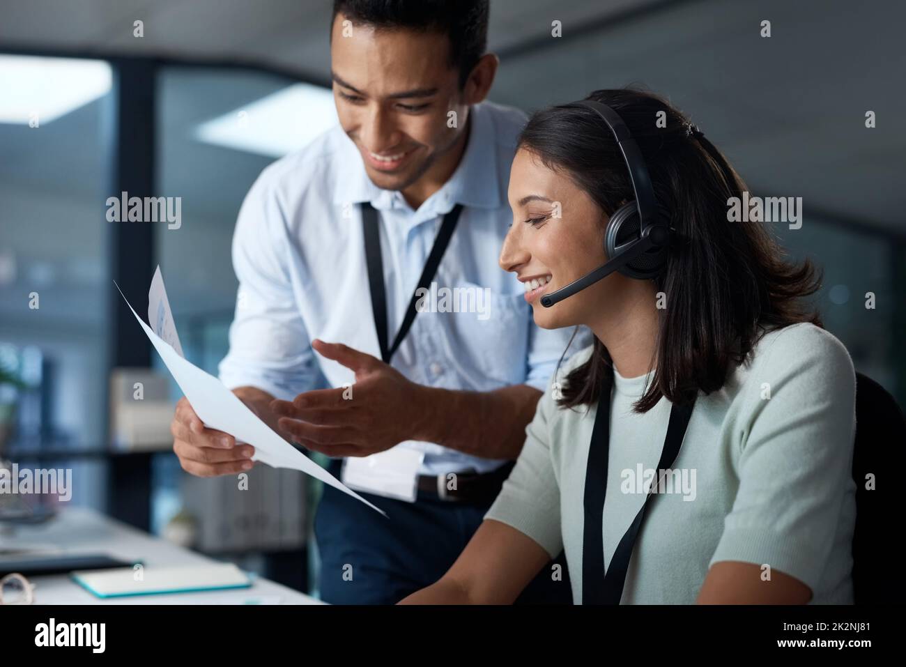 Le service est excellent. Photo d'un jeune homme et d'une jeune femme lisant un document tout en travaillant dans un centre d'appels. Banque D'Images