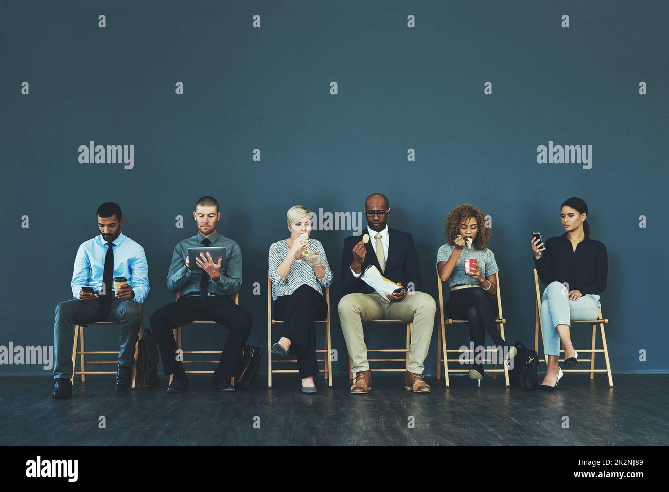 Faites ce que vous devez être préparé. Photo d'un groupe de gens d'affaires bien habillés assis dans la file en attendant d'être interviewés. Banque D'Images