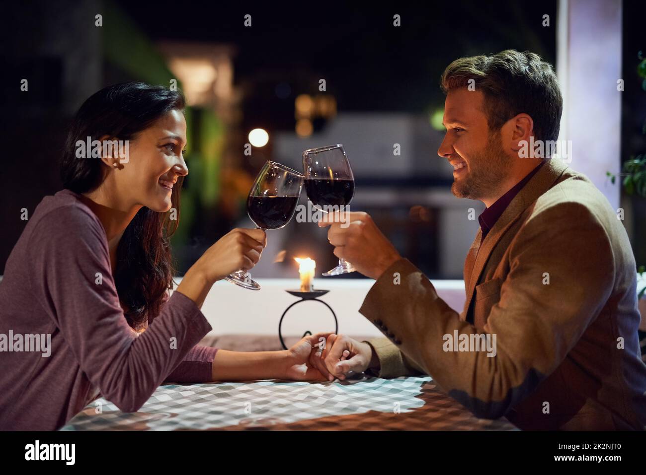 Heres à beaucoup d'autres moments magiques ensemble. Photo courte d'un jeune couple affectueux qui dîne en amoureux dans un restaurant. Banque D'Images