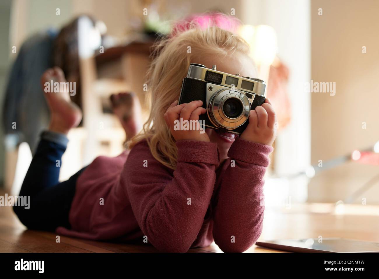 Puis-je avoir le sourire. Photo d'une petite fille prenant une photo avec un appareil photo. Banque D'Images