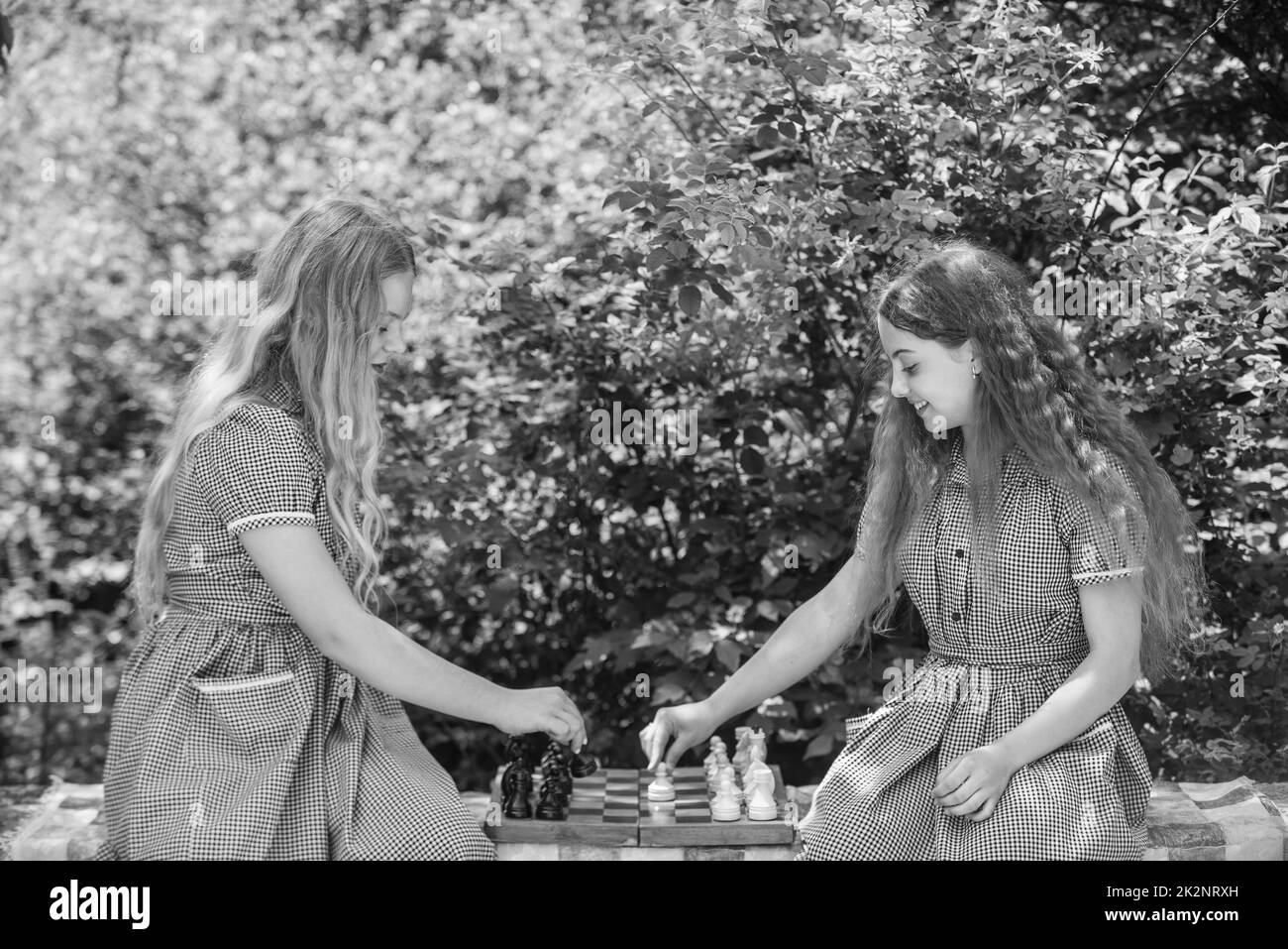 deux adolescentes jouent aux échecs dans la robe rétro en plein air, stratégie Banque D'Images