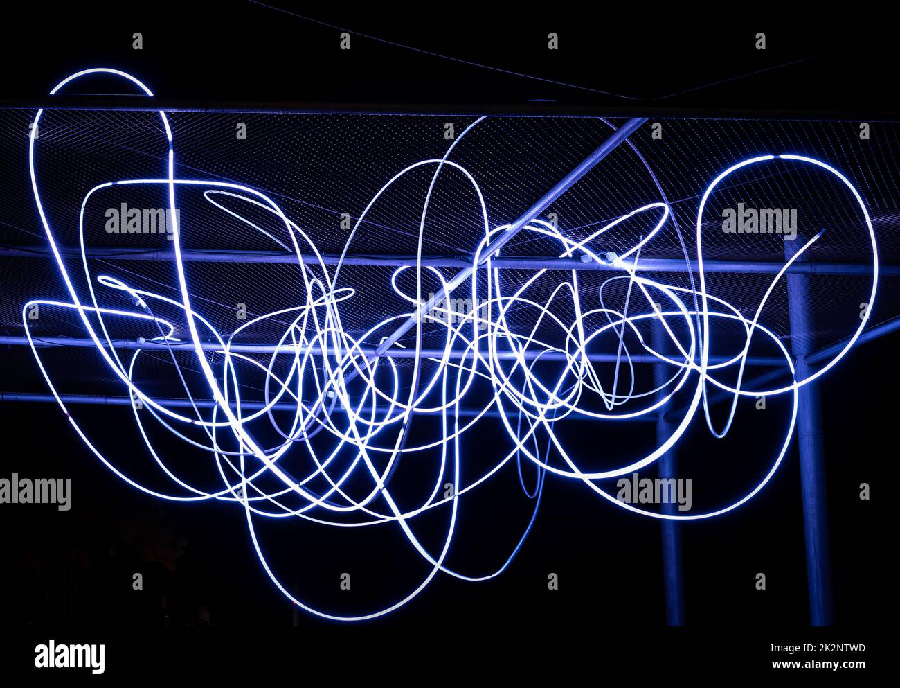 Le flux d'électrons sous forme de faisceaux de lumière spaghetti est allumé en blanc. Un faisceau lumineux de LED blanches indique un flux de particules électriques ou des photons lumineux Banque D'Images