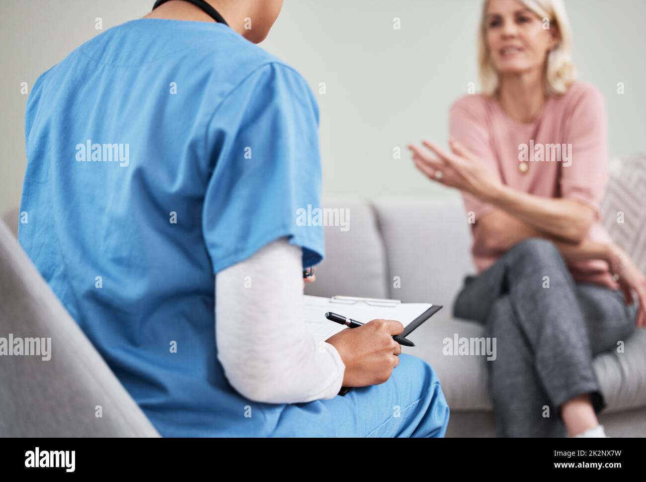 Un bon auditeur fait un bon médecin. Prise de vue d'une infirmière féminine assise avec un presse-papiers tout en ayant une consultation avec un patient. Banque D'Images