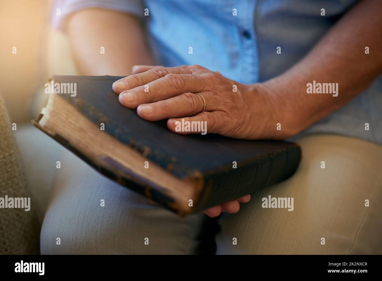 C'est là que réside tout l'espoir dont vous avez besoin. Gros plan d'une femme âgée tenant une Bible à la maison. Banque D'Images