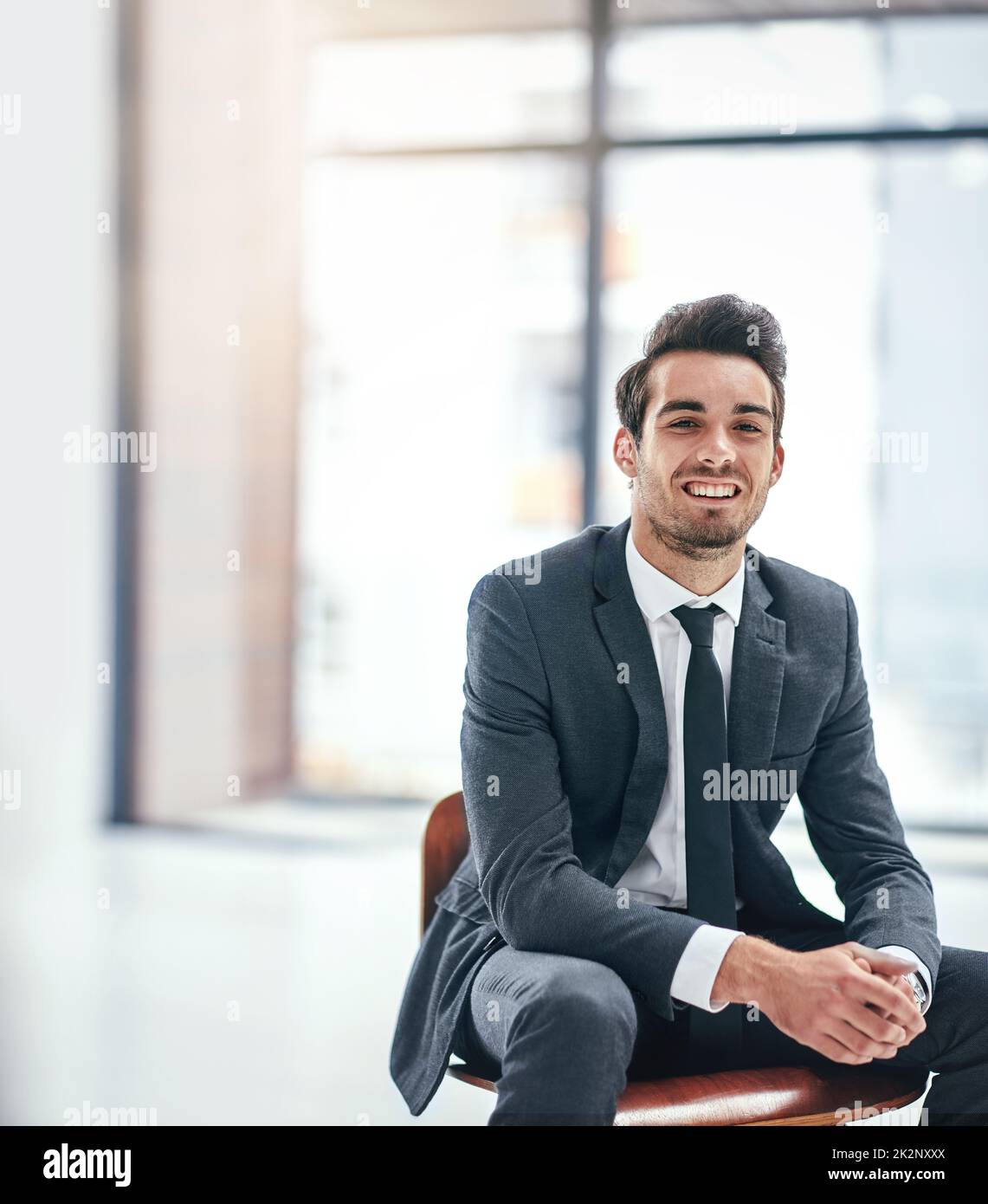 Le bonheur est un travail que vous aimez. Portrait d'un jeune homme d'affaires heureux posant dans le bureau. Banque D'Images