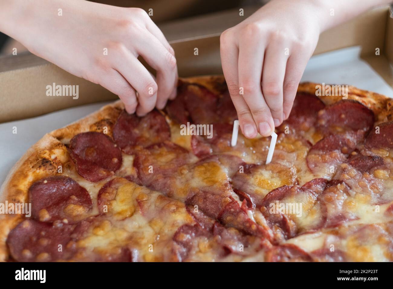 Gros plan de la main d'un homme prenant une tranche de pizza pepperoni. Pizza avec salami et fromage Banque D'Images