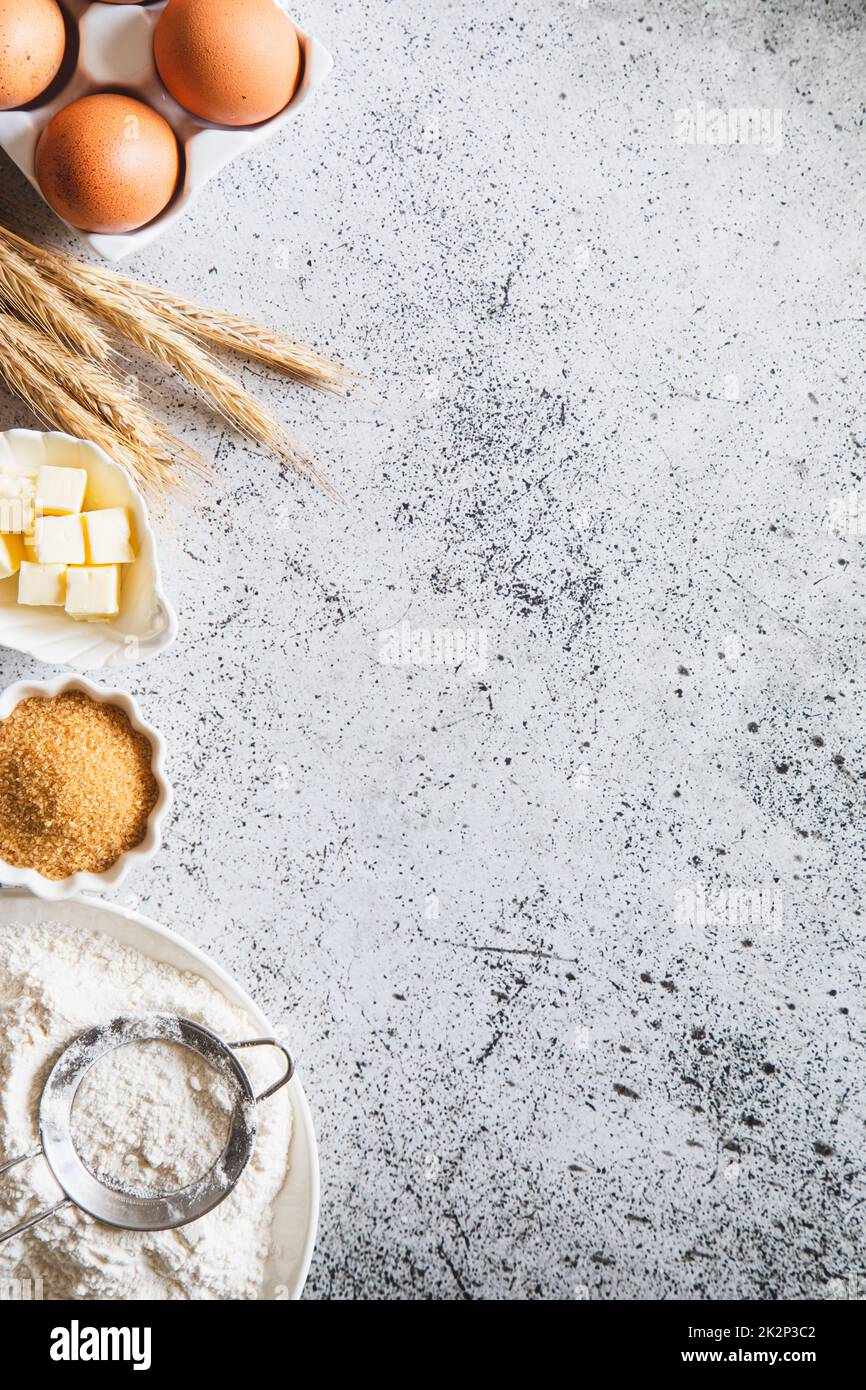 Cadre de cuisson ou de cuisson. Ingrédients, articles de cuisine pour cuire des gâteaux. Ustensiles de cuisine, farine, œufs, cassonade, beurre. Espace texte, vue de dessus. Maquette de tarte ou de recette de gâteau aux biscuits Banque D'Images