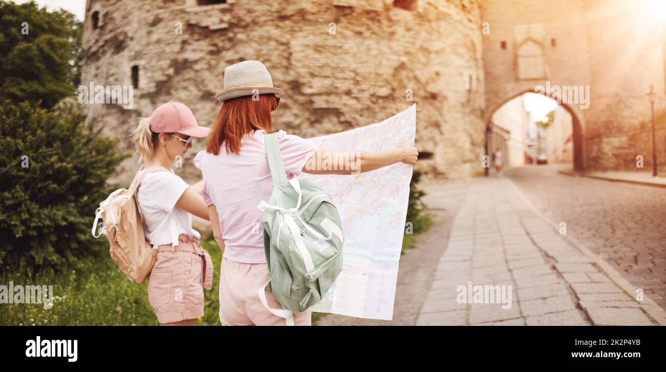 Deux femmes à la recherche de l'emplacement des sites touristiques sur la carte de la vieille Tallinn, Estonie. Banque D'Images