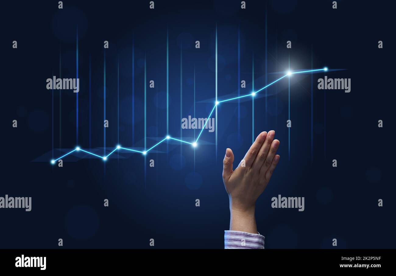 la main d'un homme d'affaires montre un graphique holographique avec des taux en hausse sur fond bleu. Développement d'une entreprise avec des profits élevés, la perspective de mettre en œuvre des plans d'affaires Banque D'Images