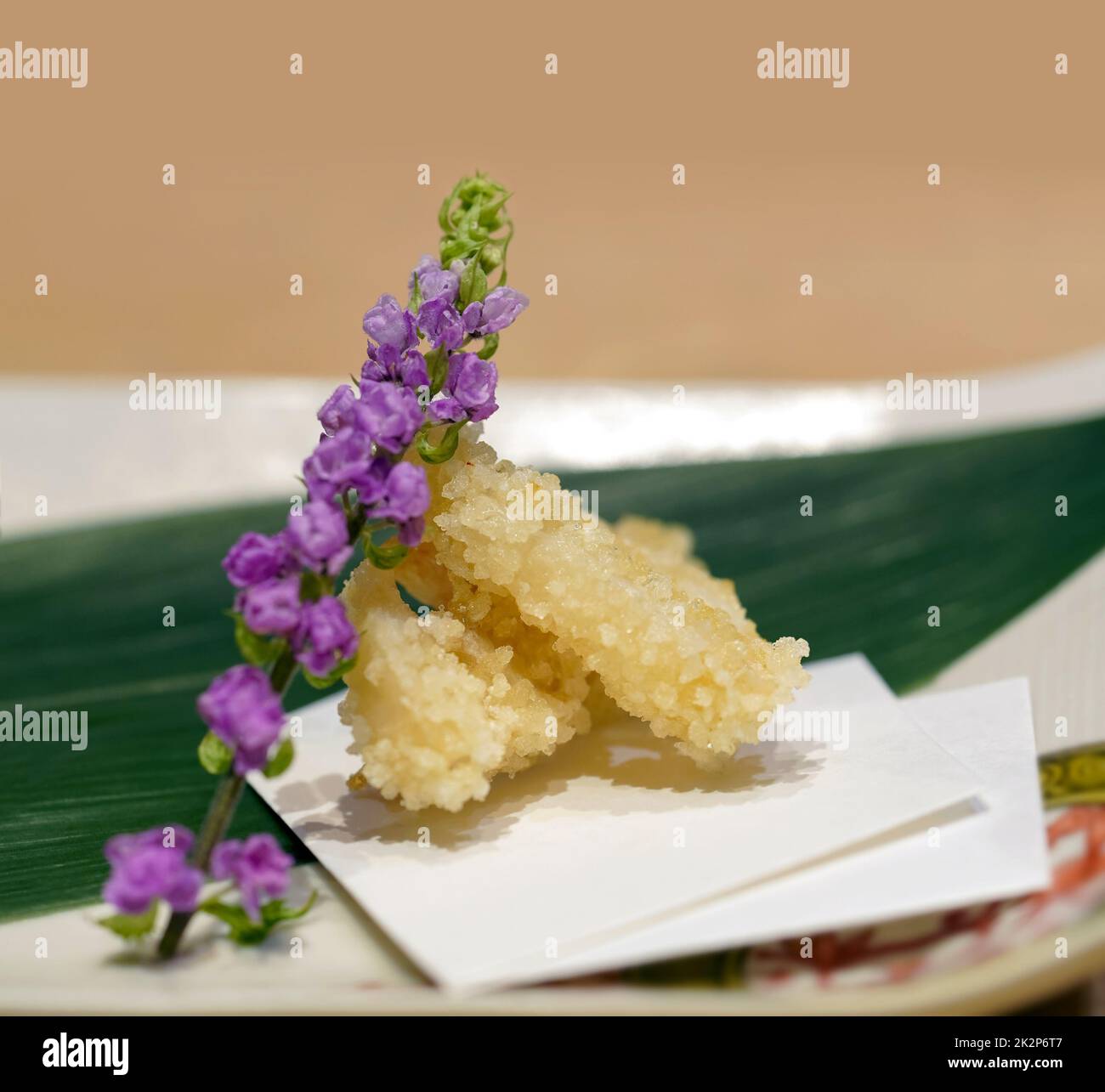 Tempura de poisson servi sur une assiette en céramique décorée de fleurs de la petite tortue et de feuilles de bambou. Menu d'apéritif Omakase au restaurant japonais Sushi. Banque D'Images