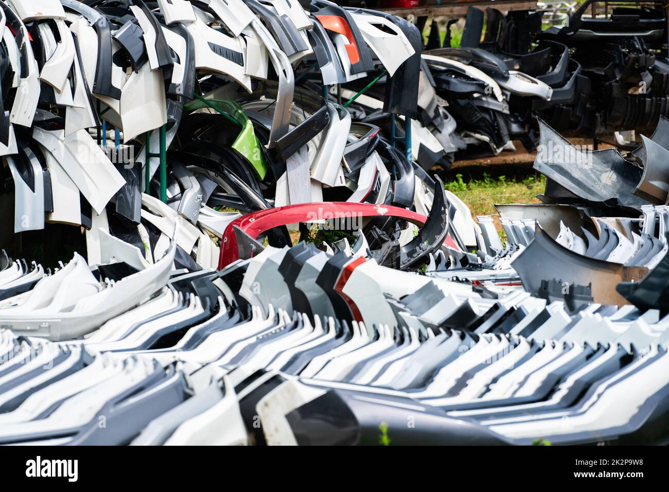 Pile de pare-chocs avant, de pare-chocs arrière et d'aileron de voiture usagés à recycler. Produits de pièces automobiles en fibre de carbone, en plastique pu et PP. Industrie automobile. Démolition de l'ancien pare-chocs, aileron. Déchets plastiques. Banque D'Images