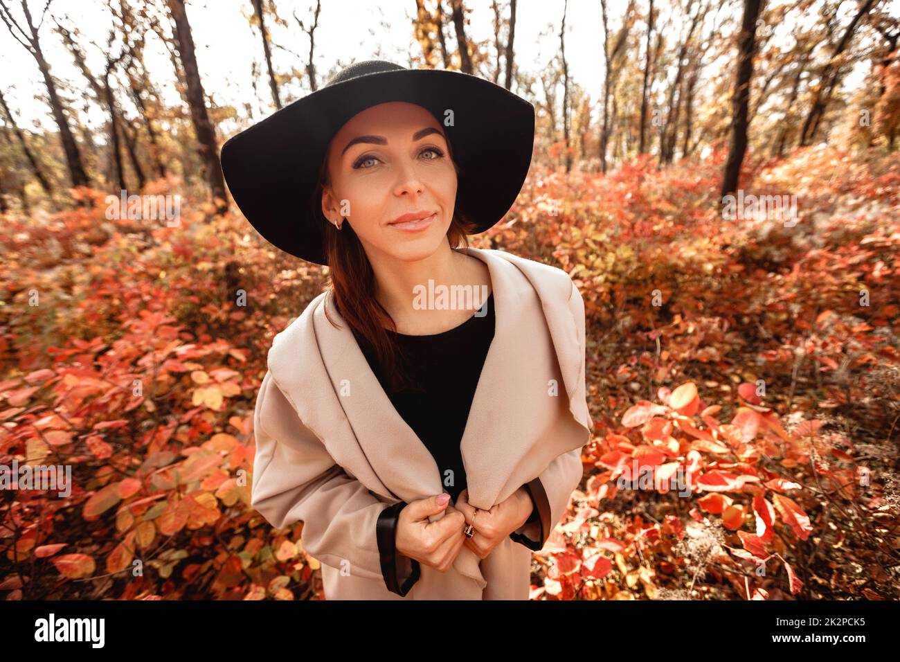 Femme en robe et chapeau sur fond de feuillage de l'automne Banque D'Images