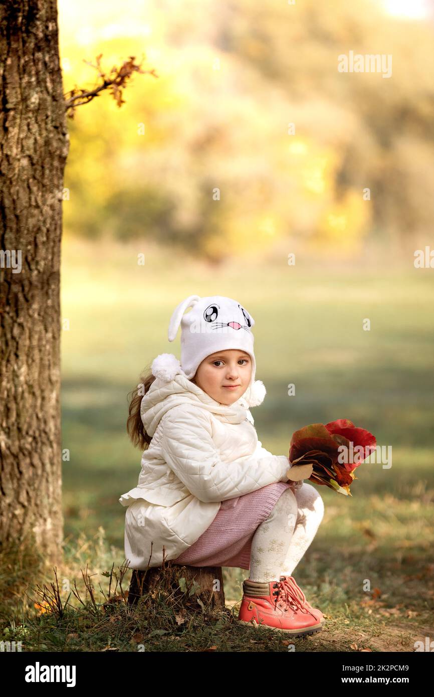 Baby Girl ramasser un bouquet de feuilles jaunes sur jour d'automne Banque D'Images