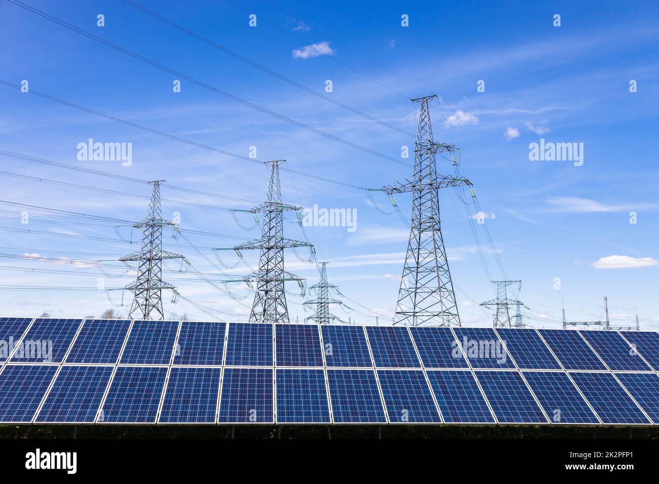 Panneaux solaires, tours d'électricité haute tension et lignes électriques de transmission Banque D'Images