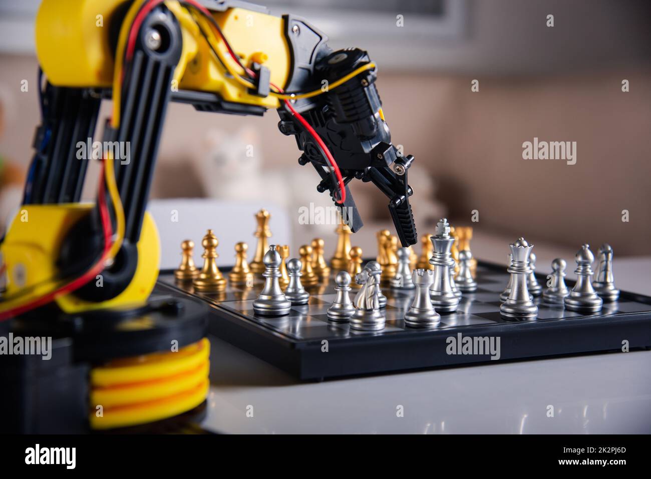 Gros plan bras robot jaune jouant déplacer des échecs sur l'échiquier Banque D'Images