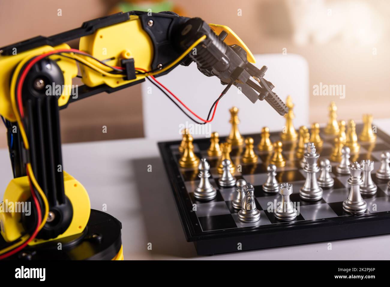 Gros plan bras robot jaune jouant déplacer des échecs sur l'échiquier Banque D'Images