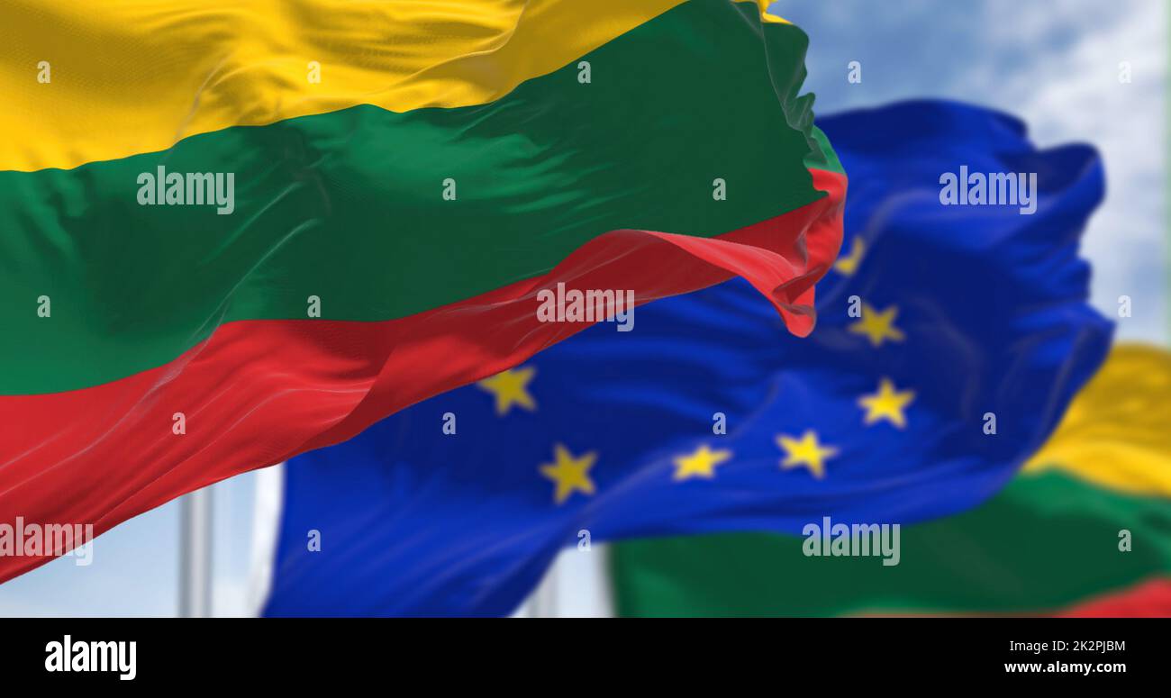 Détail du drapeau national de la Lituanie agitant dans le vent avec le drapeau flou de l'Union européenne en arrière-plan par temps clair. Démocratie et politique. Banque D'Images