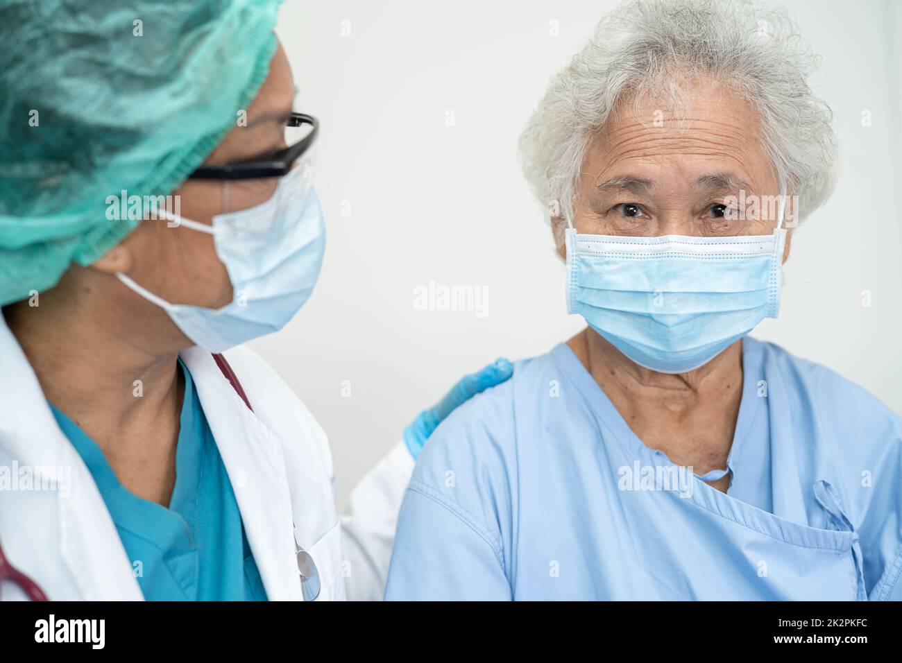 Aide médicale asiatique senior ou âgée femme âgée patient portant un masque facial à l'hôpital pour protéger l'infection de sécurité et tuer le coronavirus Covid-19. Banque D'Images